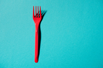 top view of red plastic fork isolated on blue