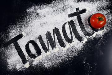 The inscription on the flour. Tomato. Black background