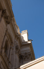 zdobiony zabytkowy fragment antycznego budynku z błękitnym niebem w tle 