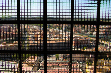 widok miasta z góry przez zakratowane okno
