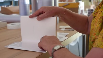 Librarian covers a book with a plastic film - Powered by Adobe