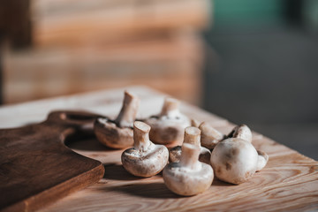 close up of mushrooms laying on wooden table near board at backyard, cooking