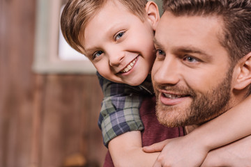 young father with little son sitting on porch at backyard, dad and son playing