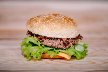 close up view of freshly cooked meat burger on wooden tabletop