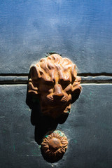brązowa kołatka z głową lwa na granatowym tle - obrazy, fototapety, plakaty