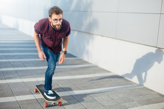 Hipster man riding skateboard