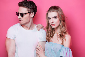 Stylish young couple in love posing together isolated on pink