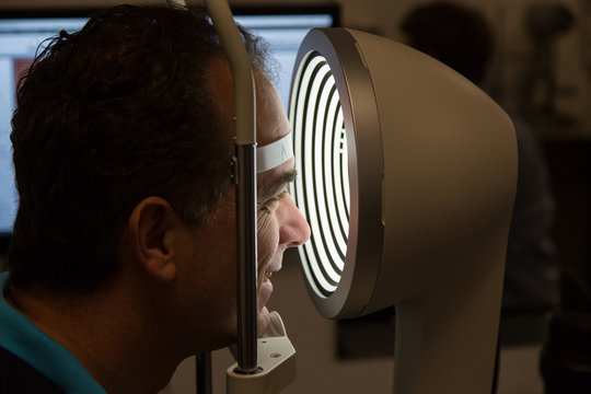 patient in corneal topograph at opticians shop