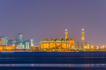 Al Fateh Grand mosque reflecting on sea during sunset