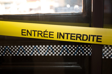 yellow banner where is written in French forbidden entry, for a zone protected by the police in...