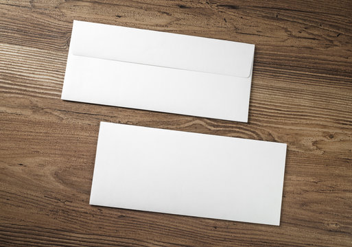 Two blank envelopes on wood table background. Front and back side.