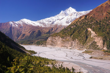 Himalaya mountains. Local village at Kali Gandaki river valley with Mt. Dhaulagiri summit on background. Road to Muktinath, saint place for hinduists and buddhists, Annapurna Circuit, Nepal, Asia