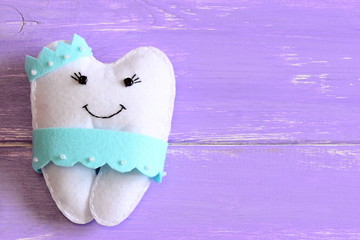 Felt tooth fairy pillow isolated on wooden background with copy space for text. Handmade children's...