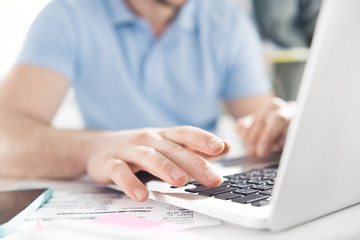 close up of casual businessman working on laptop at modern office, business men computer