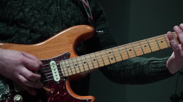 The man is masterly playing an electric guitar at a rock concert. close-up. In slow motion.