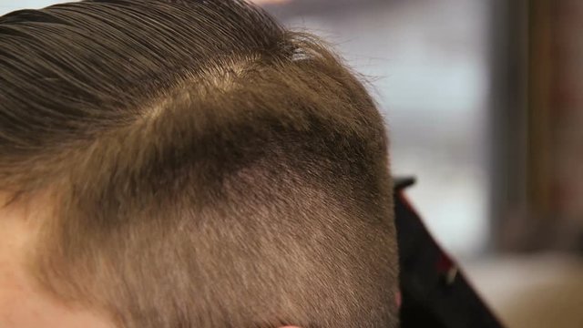 Man Barber Cuts the Client's Hair with a Clipper Hair in The Hairdresser's