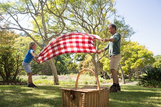 Father and son spreading the picnic blanket