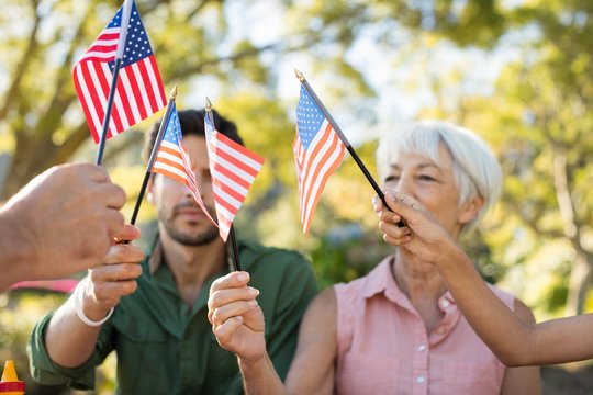Family holding American flags in the park