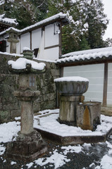 Fototapeta premium A stone lantern and moss covered with snow on top.