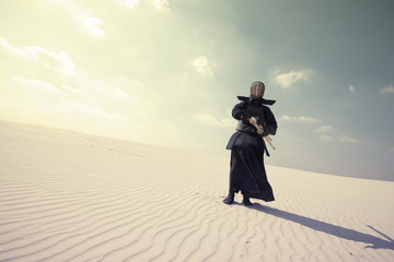 Warrior in traditional armor for kendo in a desert