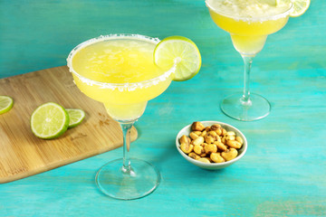 Margarita cocktails on vibrant blue background with copyspace