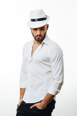 Bearded man with a hat posing in the studio