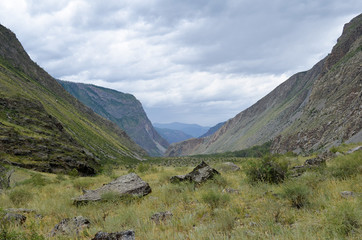 Obraz premium Mountain valley and mountains on a cloudy summer day.
