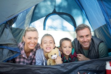 Smiling family lying in the tent