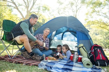 Family having snacks and coffee outside the tent - obrazy, fototapety, plakaty