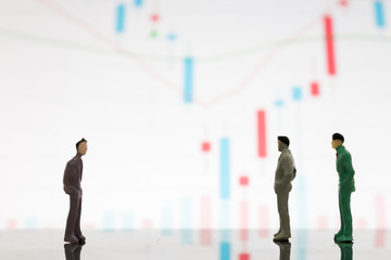 Miniature figures businessman standing on a graph chart