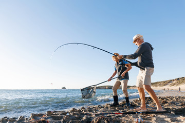 Senior man fishing with his grandson