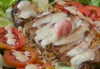 rill pork sliced Salad on vegetable and pour with salad dressing in the blue dish