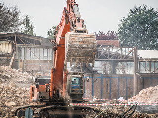 Bagger reisst Fabrikgebäude ab