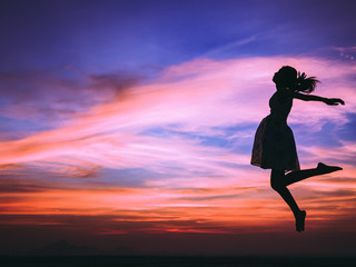 Silhouette of free woman enjoying freedom feeling happy at sunset. relaxing woman in pure happiness