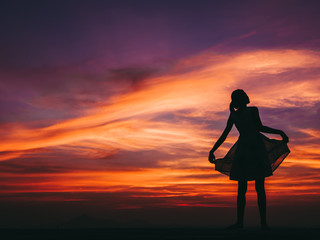 Silhouette of free woman enjoying freedom feeling happy at sunset. relaxing woman in pure happiness