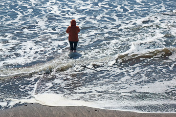 Woman wading in the ocean.