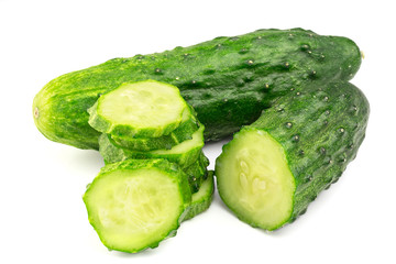 Cucumber and slices on pile, isolated on white background, close-up view