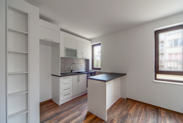 New modern and empty white kitchen. New home. Interior photography. Wooden floor.
