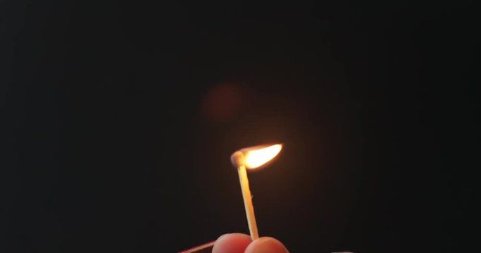 Striking a match on a matchbox with a dark background