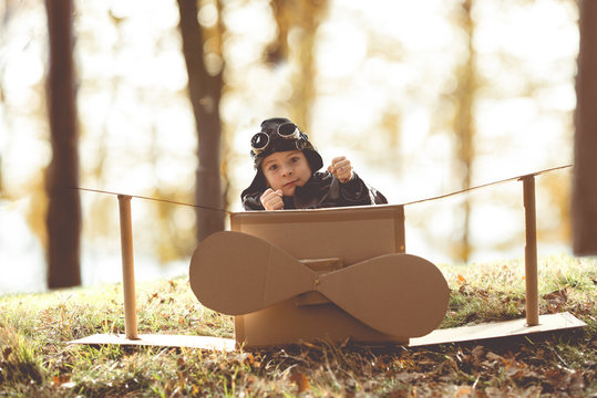 front view vintage pilot boy flight by imagination on cardboard plane outdoor