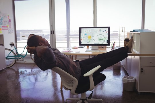 Young businessman resting on chair in creative office