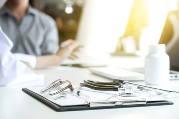 Healthcare and Medical concept, patient listening intently to a female doctor explaining patient symptoms or asking a question as they discuss paperwork together in a consultation