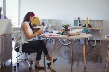 Young businesswoman working while sitting at desk in office