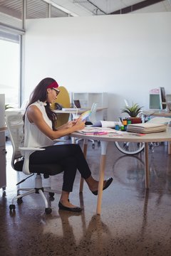 Businesswoman working while sitting at desk in office