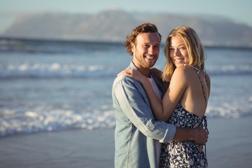 Portrait of smiling couple hugging at beach