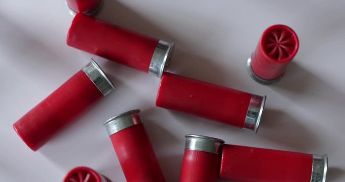 Shotgun shells scattered on white surface