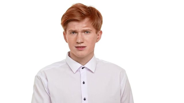 Caucasian foxy young man standing on white background standing at loss on white background in slowmotion