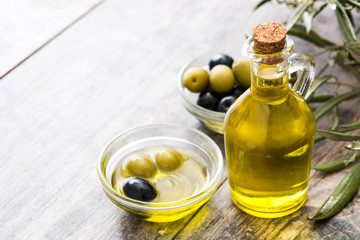 Obraz na płótnie Canvas Virgin olive oil in a crystal bottle on wooden background 