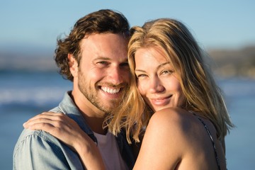 Portrait of happy couple hugging at beach