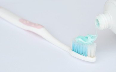 Fototapeta na wymiar toothpaste squeezing on toothbrush in white background